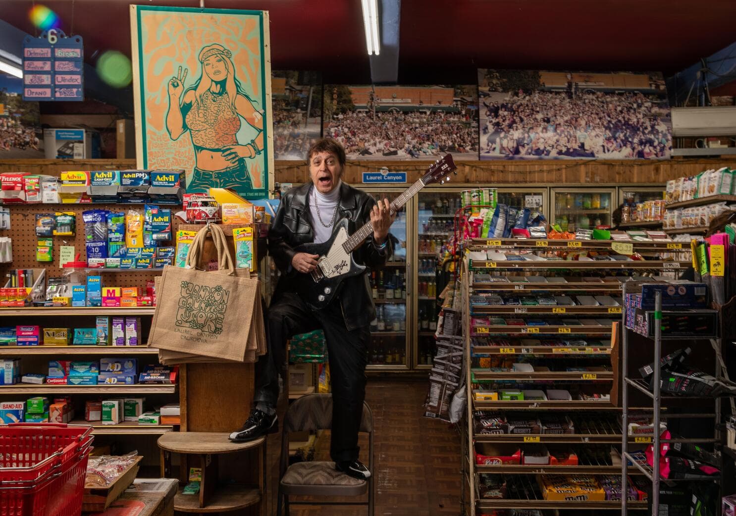 Inside the Canyon Country Store, a man in a leather jacket plays an electric guitar among the shelves